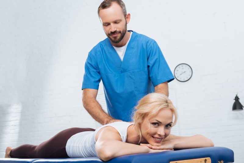 massage-therapist-doing-massage-to-smiling-woman-on-massage-table-in-clinic.jpg